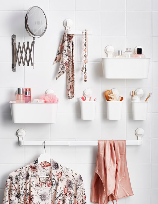小塑料篮子用吸盘吸附在浴室墙壁上，用于放置洗漱用品和其他配件。