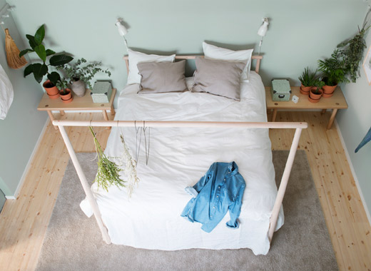 布局对称的卧室中，放着一张配有浅色天然纺织品的床，映衬着浅绿色的墙壁，一张较低的白蜡木床边桌，为家增添一抹大自然的气息