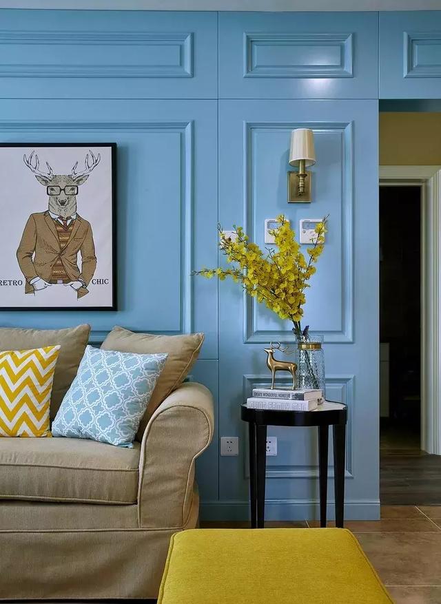 沙发的背景墙是蓝色靓丽的护墙板,搭配了非常具有童趣的壁画