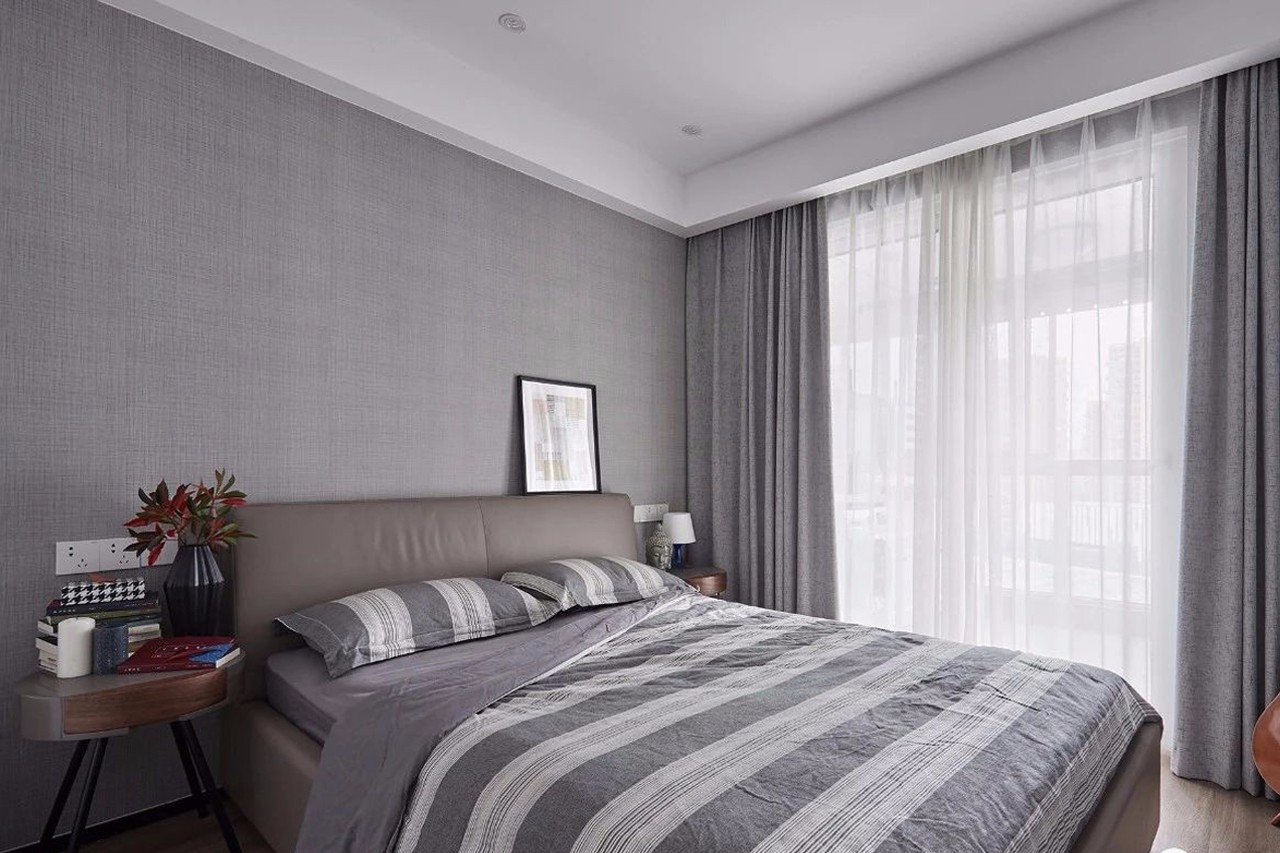 次卧,木地板搭配灰色细纹壁纸背景墙,造型圆润的边柜与皮质大床提升