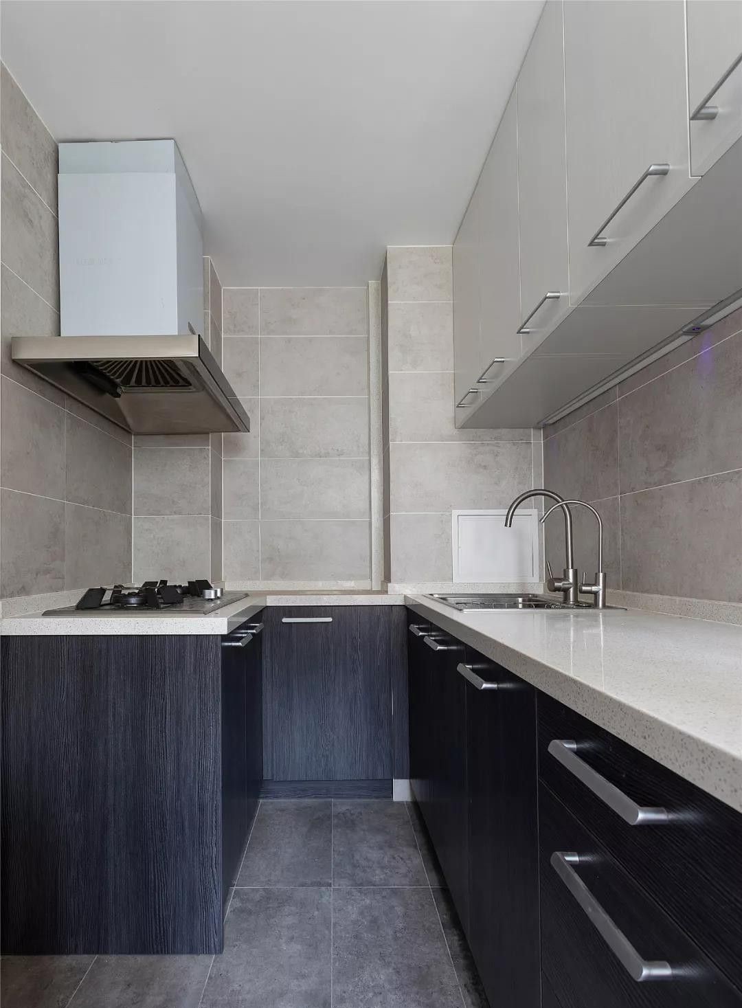 厨房做了u字型橱柜,黑色木纹的地柜配上灰白色的吊柜,简洁明净.