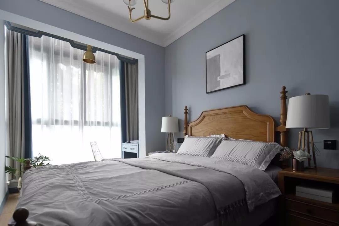 次卧室在灰蓝色的空间,搭配实木框架的布艺床与灰色床单布置,呈现出一